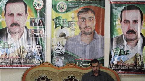 Fayeq al-Mabhouh ngồi trước ảnh anh trai mình, chỉ huy Hamas, Mahmoud al-Mabhouh (Ảnh: AP)