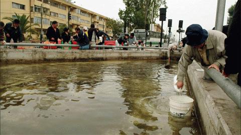 Người dân tới lấy nước sử dụng tại một vòi nước công cộng khi nguồn nước của thành phố vẫn bị cắt sau trận động đất ngày 28/2/2010 (Ảnh: Reuters)