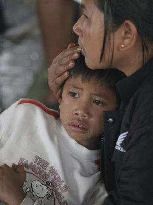 Người phụ nữ trấn an con trai mình khi họ di tản khỏi vùng ảnh hưởng của núi lửa Sinabung trong vụ phun trào vào Chủ nhật, 29/8 - Ảnh: AP.