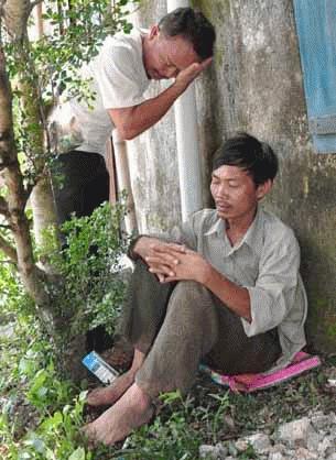 Anh Nguyễn Quang Tuấn (ngồi) không còn nước mắt để khóc con