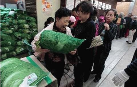 Một bà nội trợ vui mừng mua được túi cải bắp thảo sau một giờ đồng hồ xếp hàng chợ đợi ở chợ Tongin ngày 6/10 ... (Ảnh: Reuters)