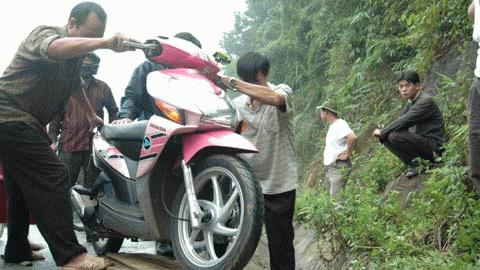 Với mỗi chiếc xe máy được dắt qua đoạn dốc bên đường, người dân thu của chủ xe 5.000đ/lượt.