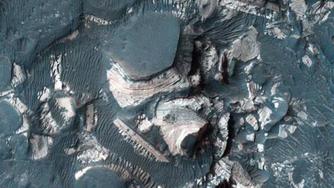 Các tầng đá màu sáng nằm xen kẽ với lớp vật chất sẫm màu hơn trong hố Holden trên sao Hỏa. Chúng được cho là kết quả của một trận lụt lớn khi nước chọc thủng miệng hố Holden.  (Ảnh NASA)