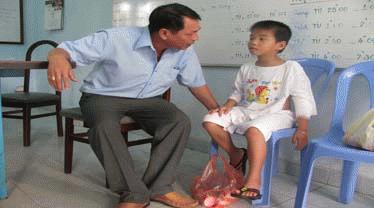 Ông Ngọc Anh (cán bộ Trung tâm Hỗ trợ Xã hội TP.HCM) đang kiểm tra sức khỏe của các cháu bé. Ảnh: Đ.Đ